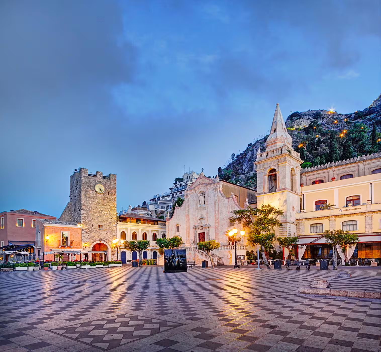 Taormina Piazza IX Aprile at dusk with church and clock tower, scenic Sicily day trip from Catania