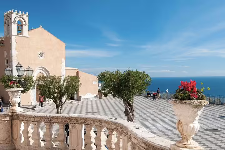 Sunny terrace and historic church in Taormina with sea views, a scenic stop on a private Mount Etna and Taormina tour from Cefalù