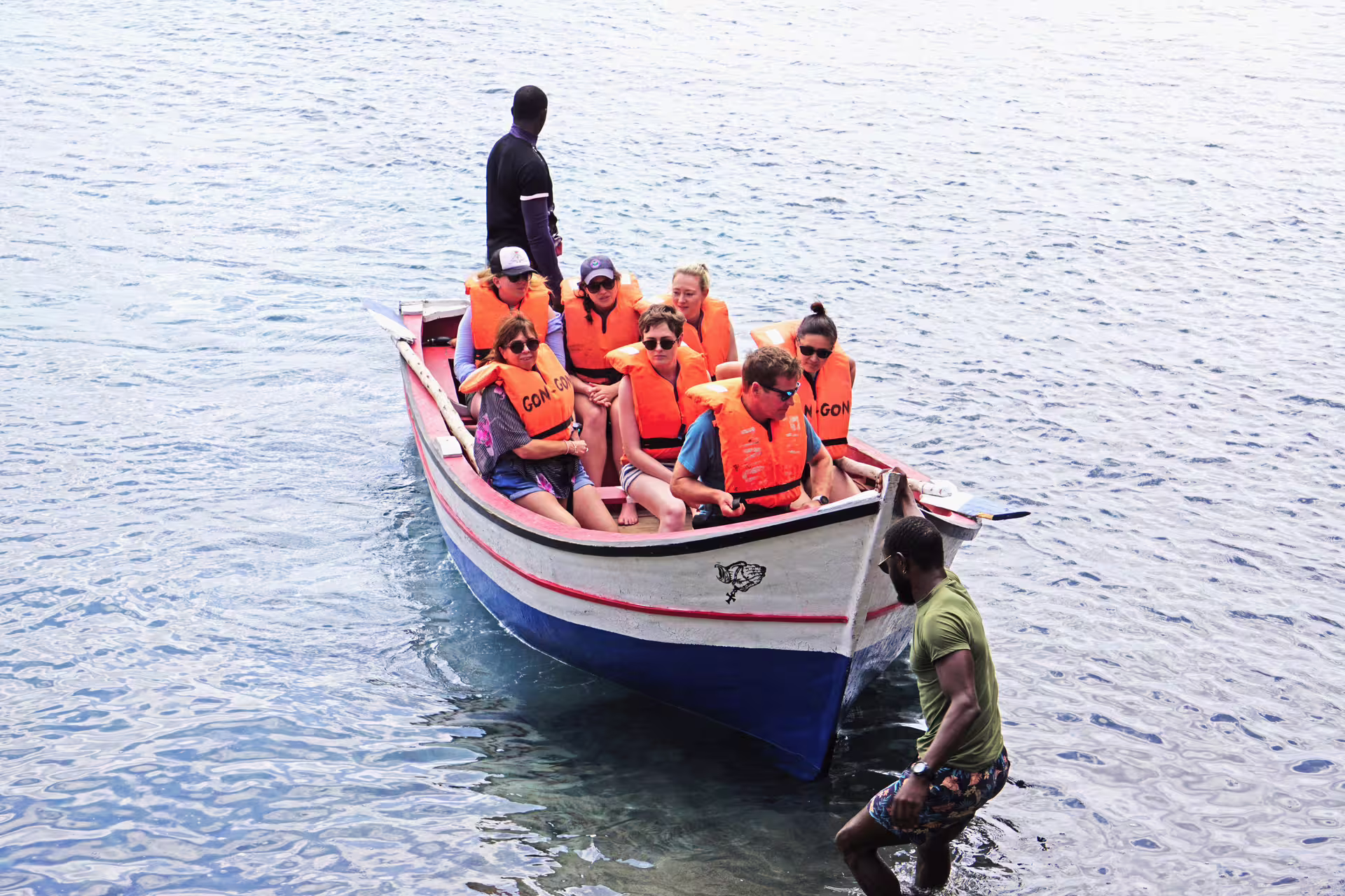 Tourists in life jackets boarding a boat for Tarrafal Beach lighthouse and snorkel tour.