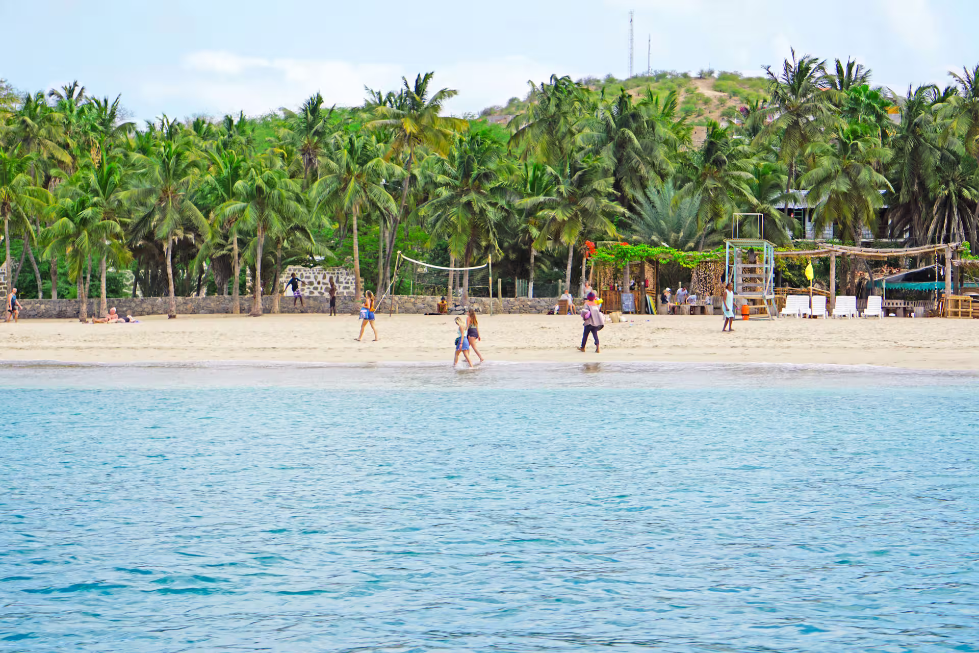 Scenic view of Tarrafal Beach with palm trees, sandy shores, and turquoise waters, ideal for a relaxing boat trip.