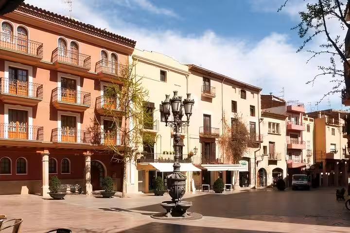 Historic Tarragona old town square with colorful facades and fountain on a private half-day trip from Barcelona