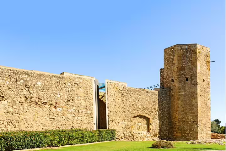 Ancient Tarragona stone wall and tower under blue sky, historic landmark on the self-guided scavenger hunt tour