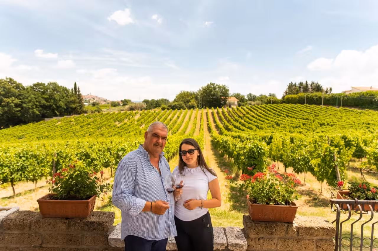 Guests savor Taurasi DOCG red wine on a vineyard terrace, overlooking rolling Irpinia vines and hills