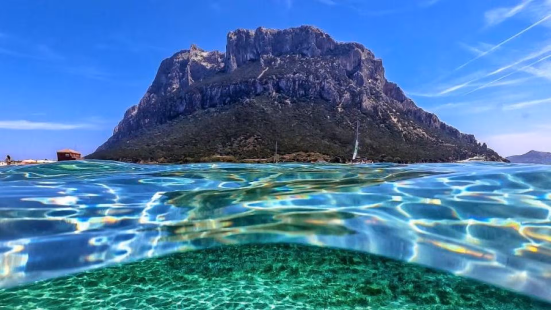 Stunning view of Tavolara Island with crystal-clear waters, ideal for boat excursions in the marine protected area.