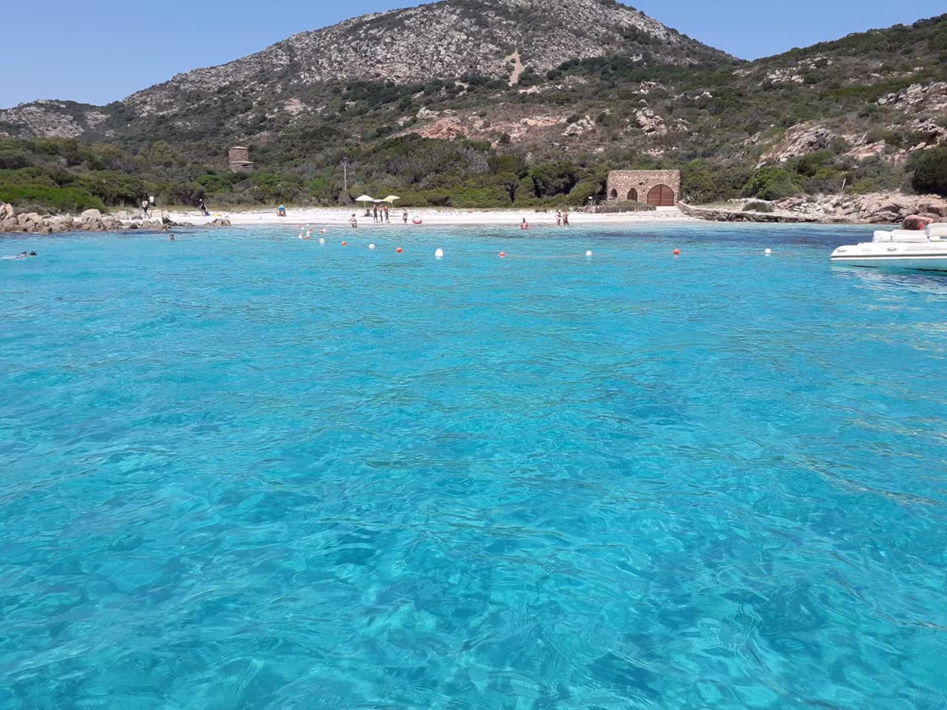 Stunning view of Tavolara Island's turquoise waters and scenic beach, perfect for a Porto San Paolo boat tour.