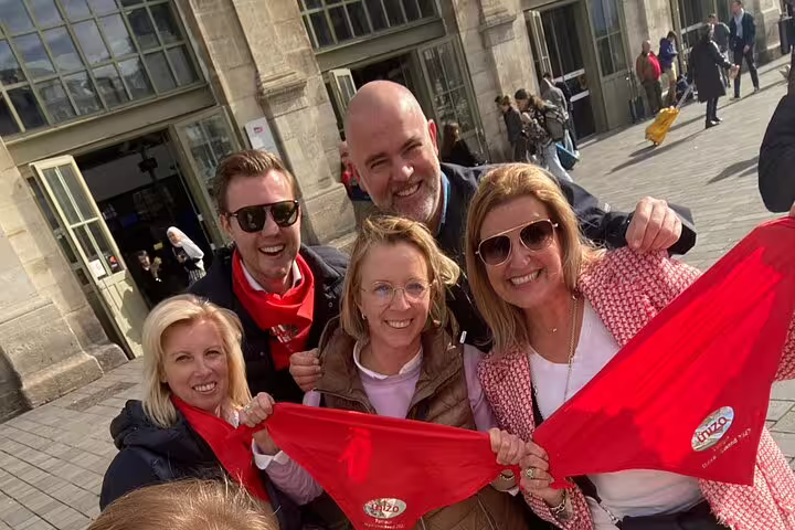 Team holding red scarves in central Marseille while playing a self-paced e-scavenger hunt city exploration game
