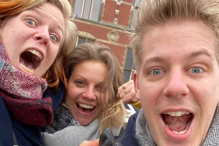 Excited team selfie in front of Maastricht historic building during e-Scavenger hunt, outdoor city game