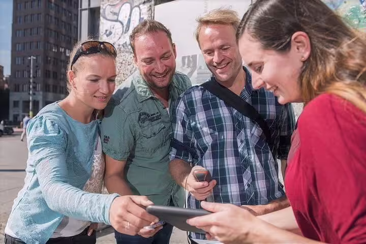 Team using a smartphone during a Milan e-scavenger hunt, completing interactive city challenges at their pace