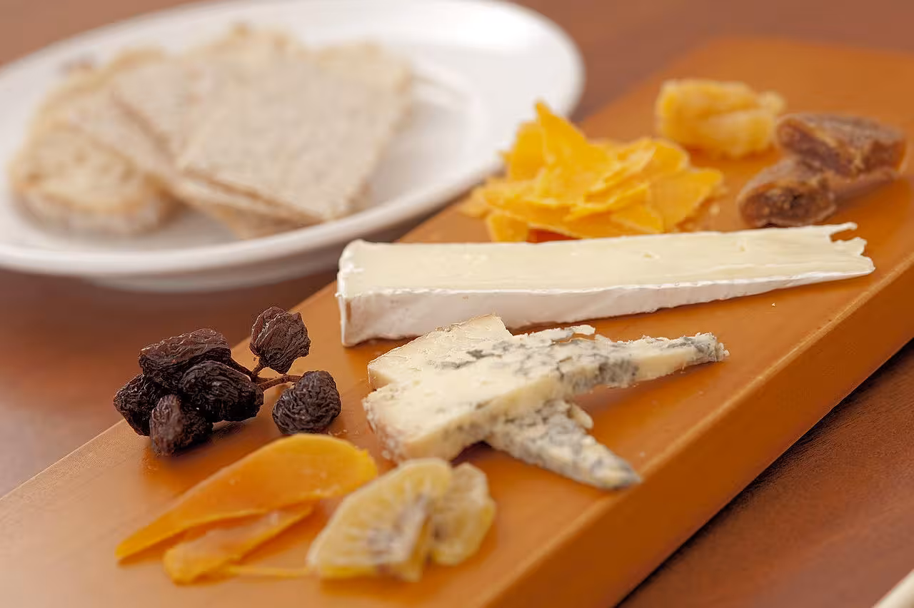 Gourmet cheese platter with dried fruits and bread, featured at Teba Cheese Festival for a delightful tasting experience.