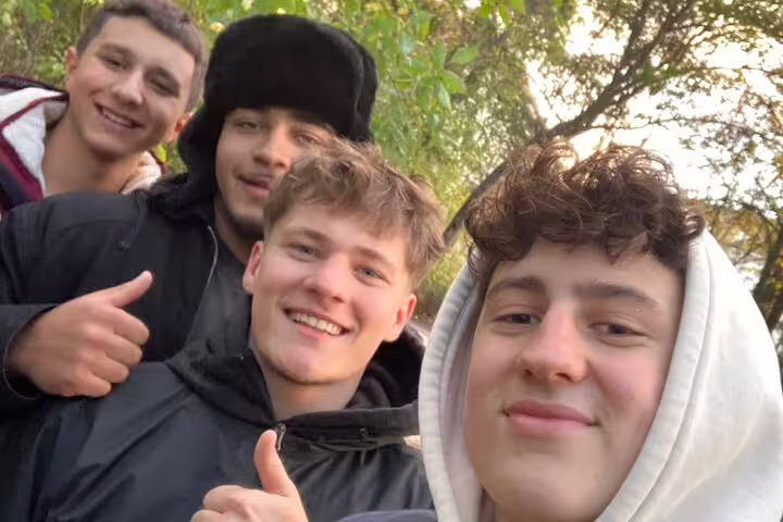 Teens smiling on a Munich scavenger hunt and sights self-guided tour, exploring parks and landmarks together