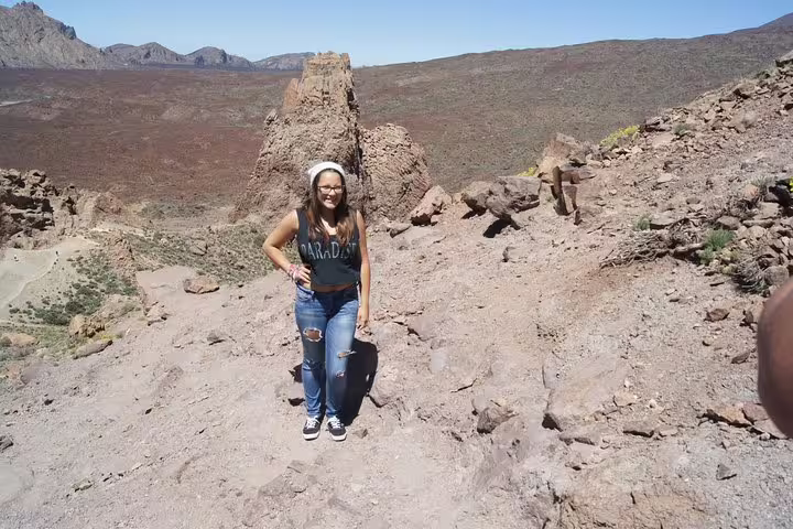 Visitor enjoys a sunny day at Teide National Park, surrounded by striking volcanic rock formations and expansive vistas.