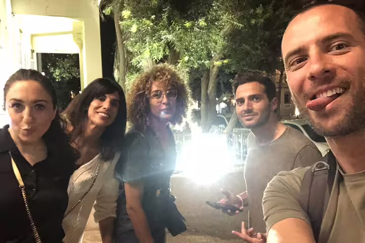 Group of five friends smiling at night during Tel Aviv walking tour spy game quest