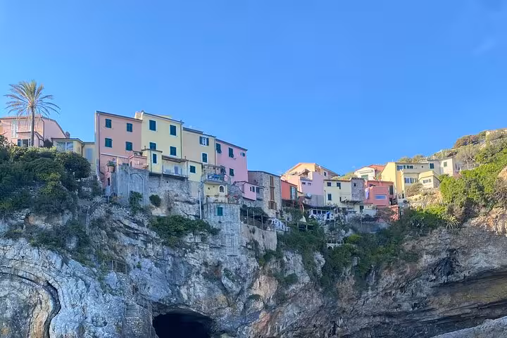 Colorful cliffside houses in Tellaro under a clear blue sky on La Spezia boat tour.