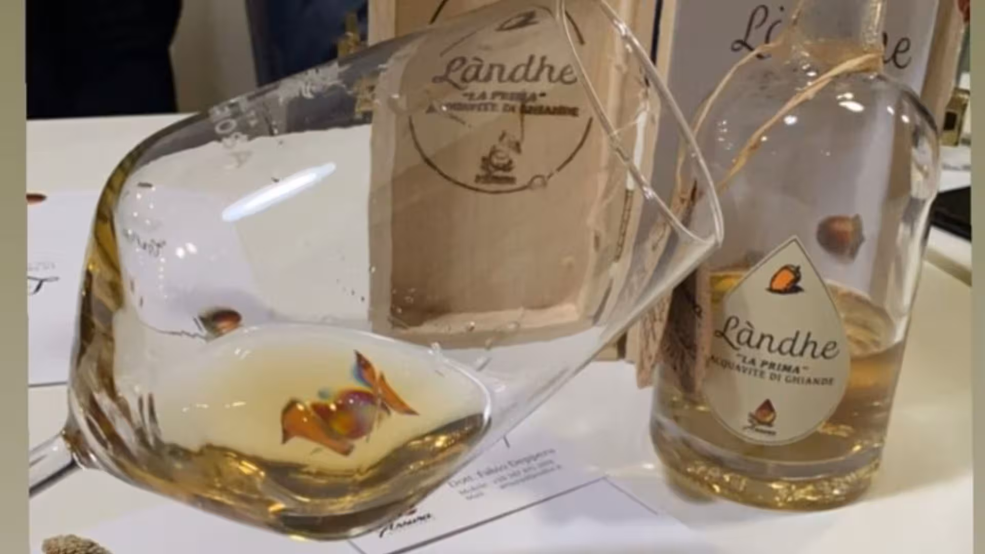 Close-up of a tasting glass and bottle of Landhe distillate, highlighting unique flavors at Tempio Pausania.