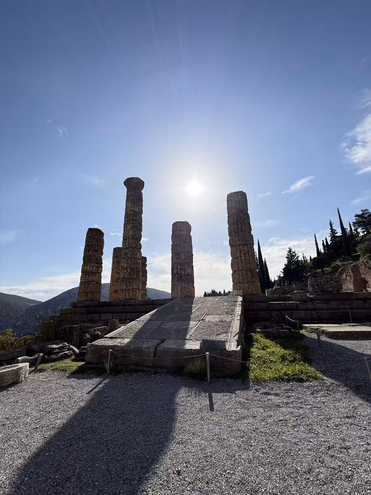 Sunlit Temple of Apollo columns at Delphi archaeological site on a private full-day tour from Athens
