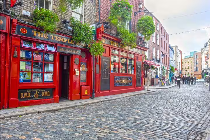 Cobblestone street with red-fronted Temple Bar pub in Dublin's historic quarter