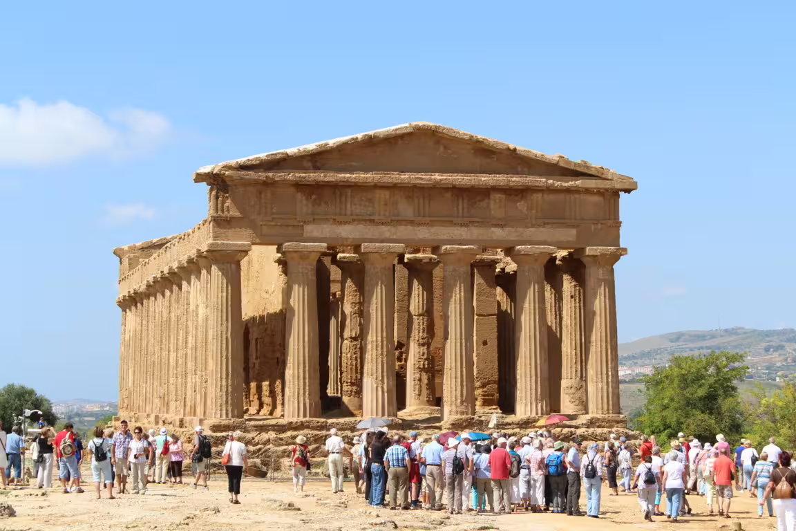 Tour group visiting Temple of Concordia at Agrigento Valley of the Temples on day tour from Taormina