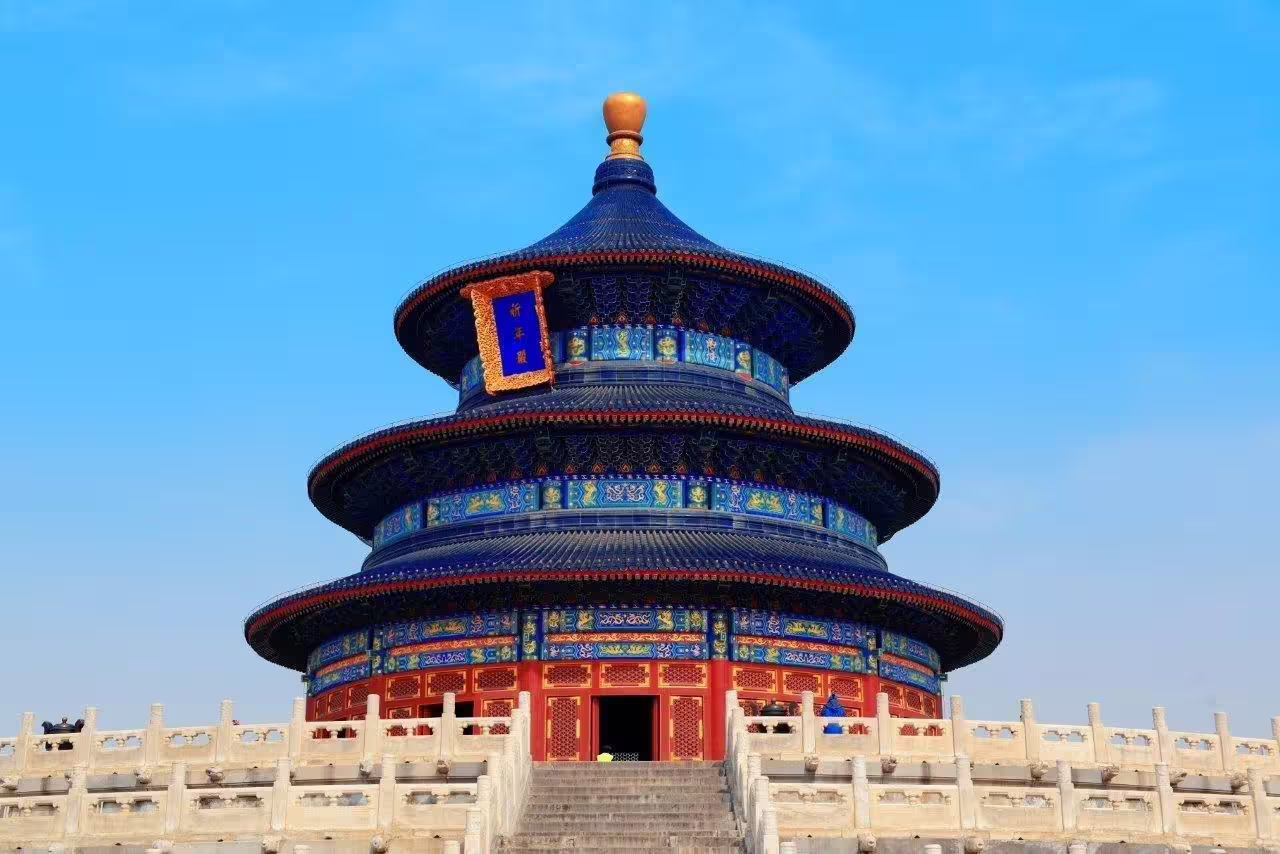 Majestic Temple of Heaven with vibrant blue tiles under a clear sky, featured in the Great Wall and Warriors tour.