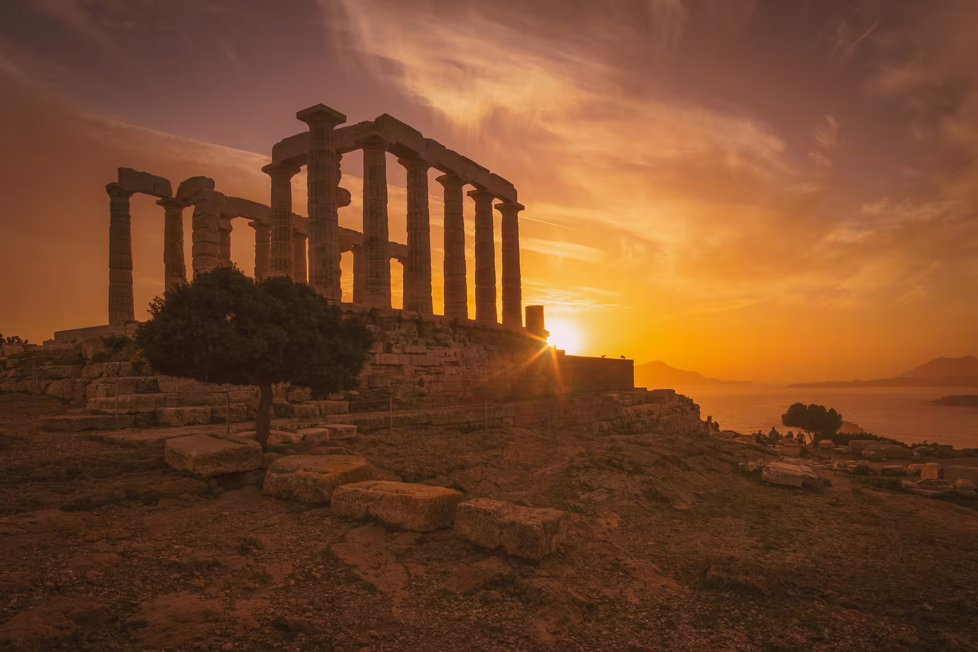 Sunset view of the Temple of Poseidon at Cape Sounion on a full-day Athens highlights tour in Greece