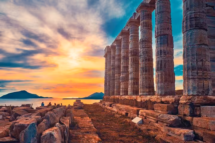 Stunning sunset view of the ancient Temple of Poseidon at Cape Sounio, highlighting its majestic columns and Aegean backdrop.