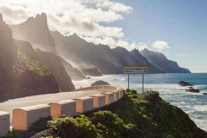 Scenic coastal road along Tenerife's rugged cliffs with ocean views, ideal for a picturesque island tour drive.