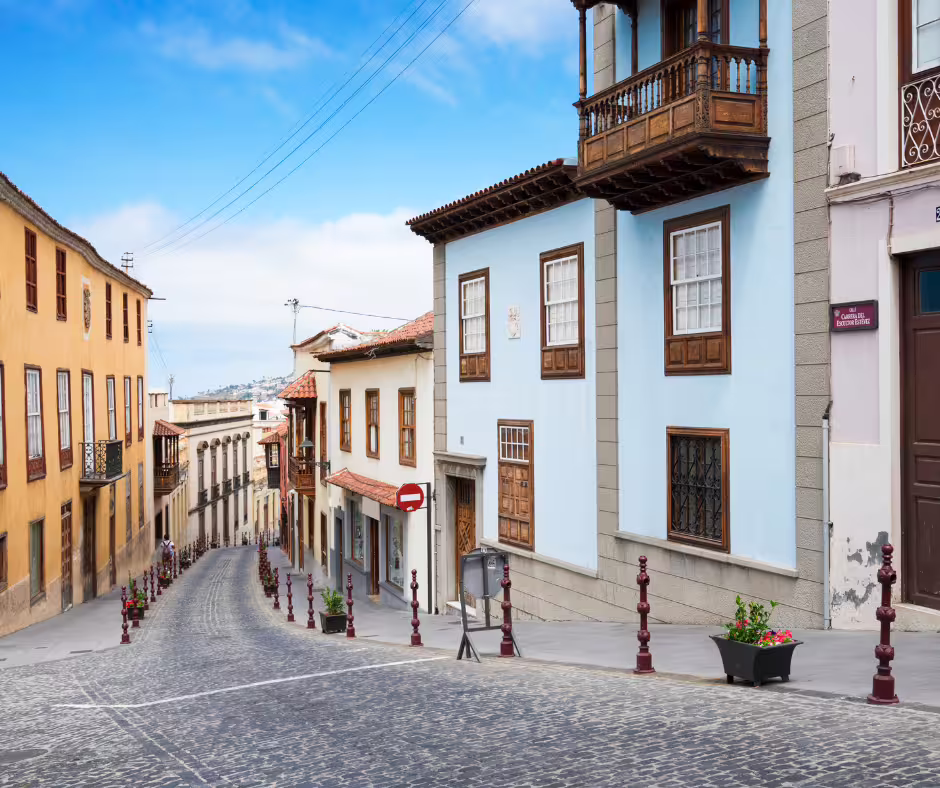 Charming cobblestone street lined with colorful historic buildings in a Tenerife town on island tour.