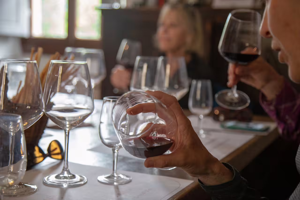 Guests swirl and sip red wine during Tenuta Bossi guided tasting, exploring three exquisite Tuscan wines