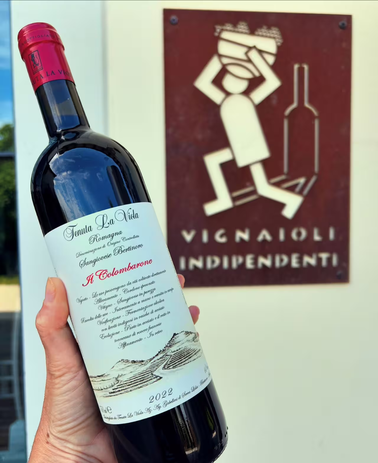 Tenuta La Viola Sangiovese bottle held by Vignaioli Indipendenti sign for Italian wine tasting tour