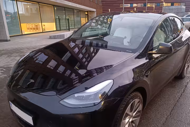Luxury Tesla airport pickup in Reykjavík for KEF International Airport, private transfer parked in city street