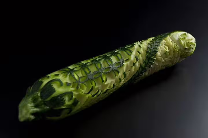 Intricately carved cucumber with geometric floral patterns showcasing Thai vegetable carving art class skills