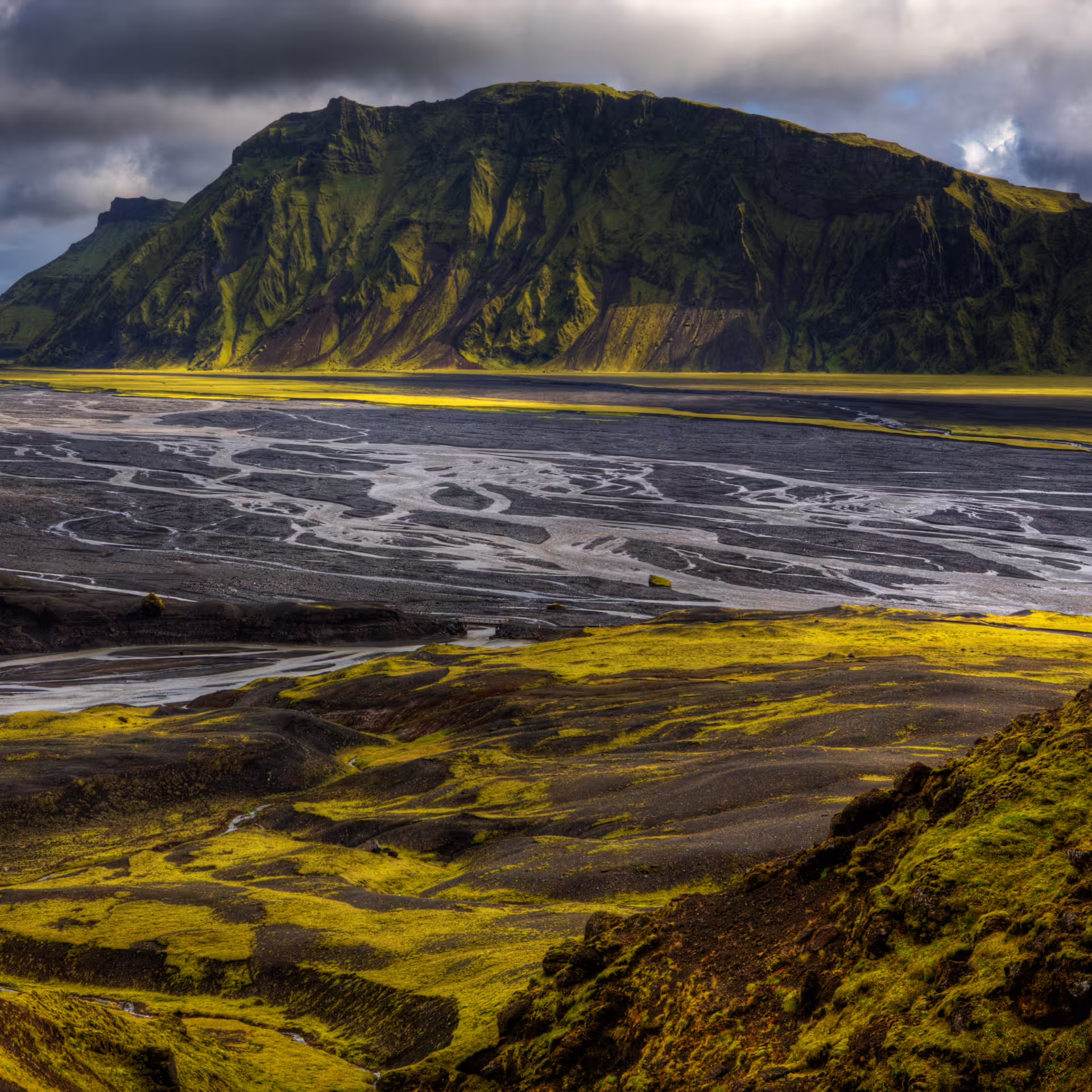 Dramatic Iceland highland landscape with black sand river plains and green moss near Vík superjeep tour