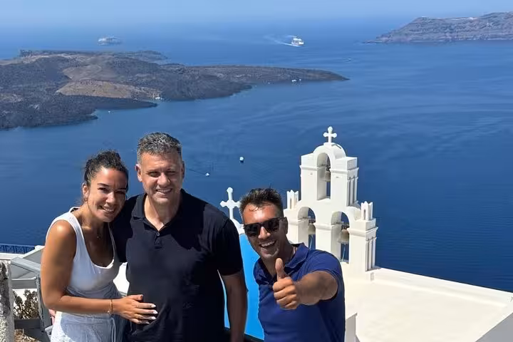 Tour guests in Fira with white church and Santorini caldera views on Thera 8-hour island tour and wine tasting