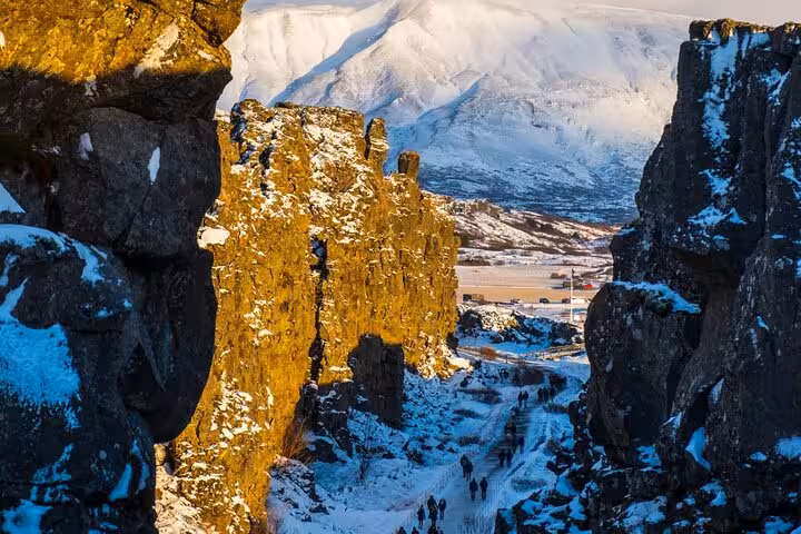 Rocky canyon path at Þingvellir National Park with snow-capped mountains on Iceland's Golden Circle