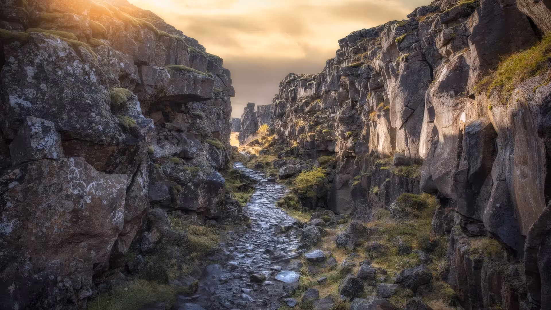 Rocky canyon path through tectonic plates at Þingvellir National Park, Iceland, at golden hour