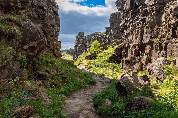 Rocky canyon path with lush green vegetation at Þingvellir National Park, Iceland
