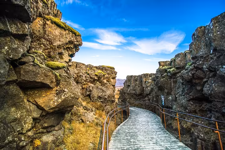 Narrow rocky canyon walkway with metal railings at Þingvellir National Park on Iceland's Golden Circle
