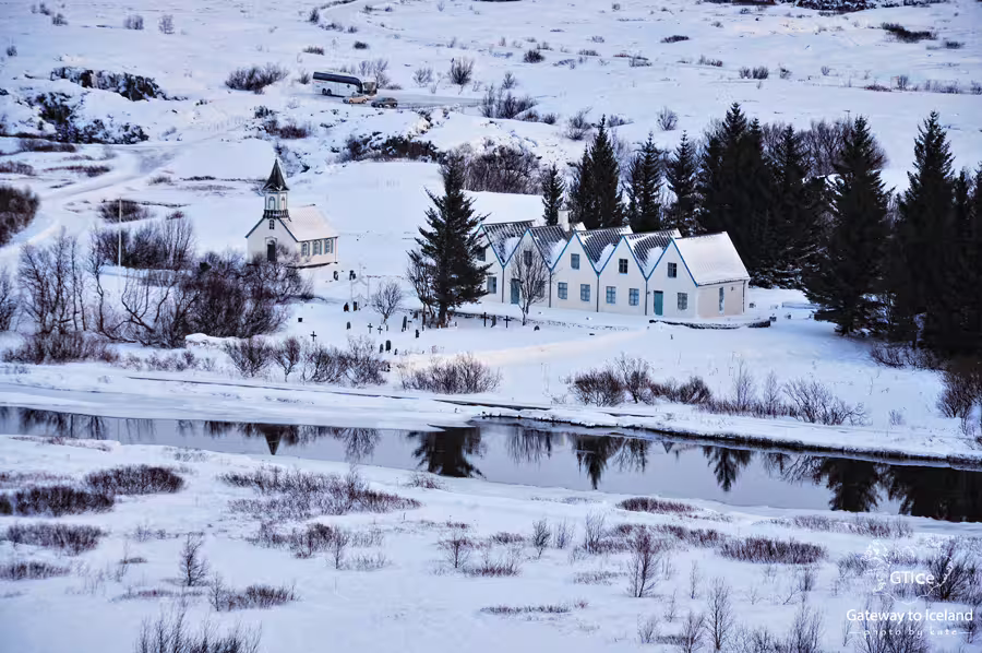 Þingvellir church and historic buildings covered in snow beside a river, Golden Circle Iceland winter