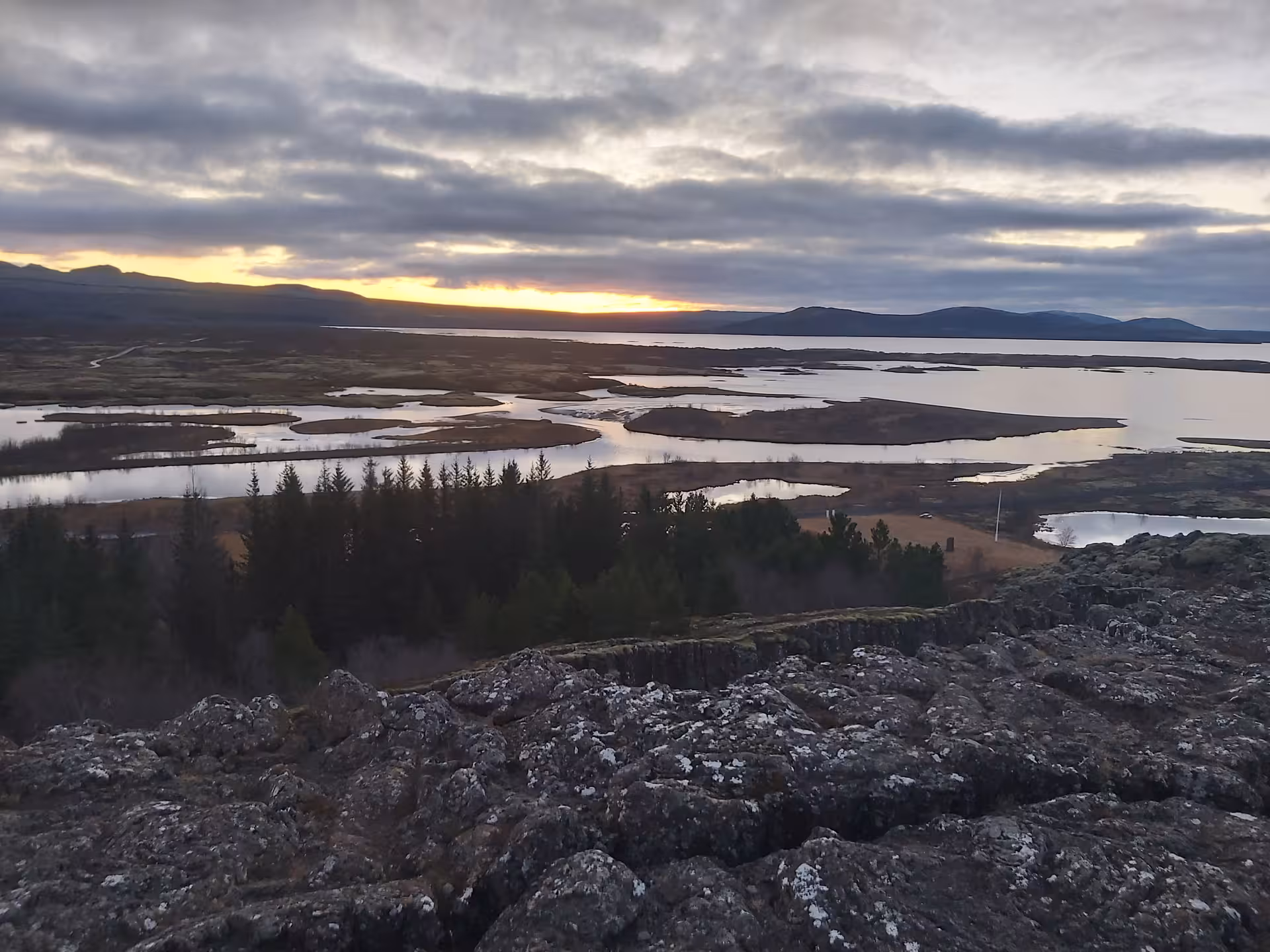 Panoramic sunset view over Þingvellir lake and wetlands from rocky lava field, Golden Circle Iceland