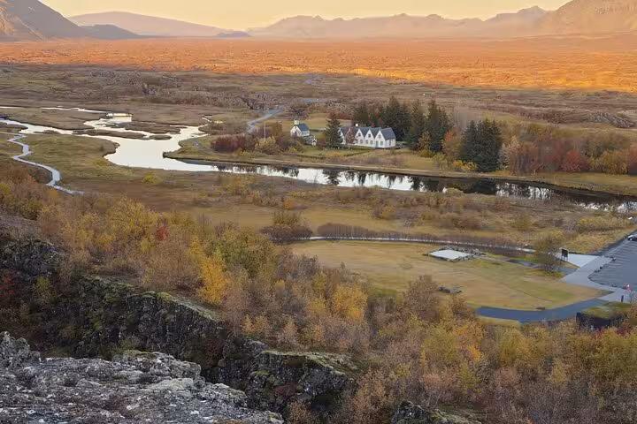 Aerial view of Þingvellir National Park valley with winding river and white church, Golden Circle Iceland
