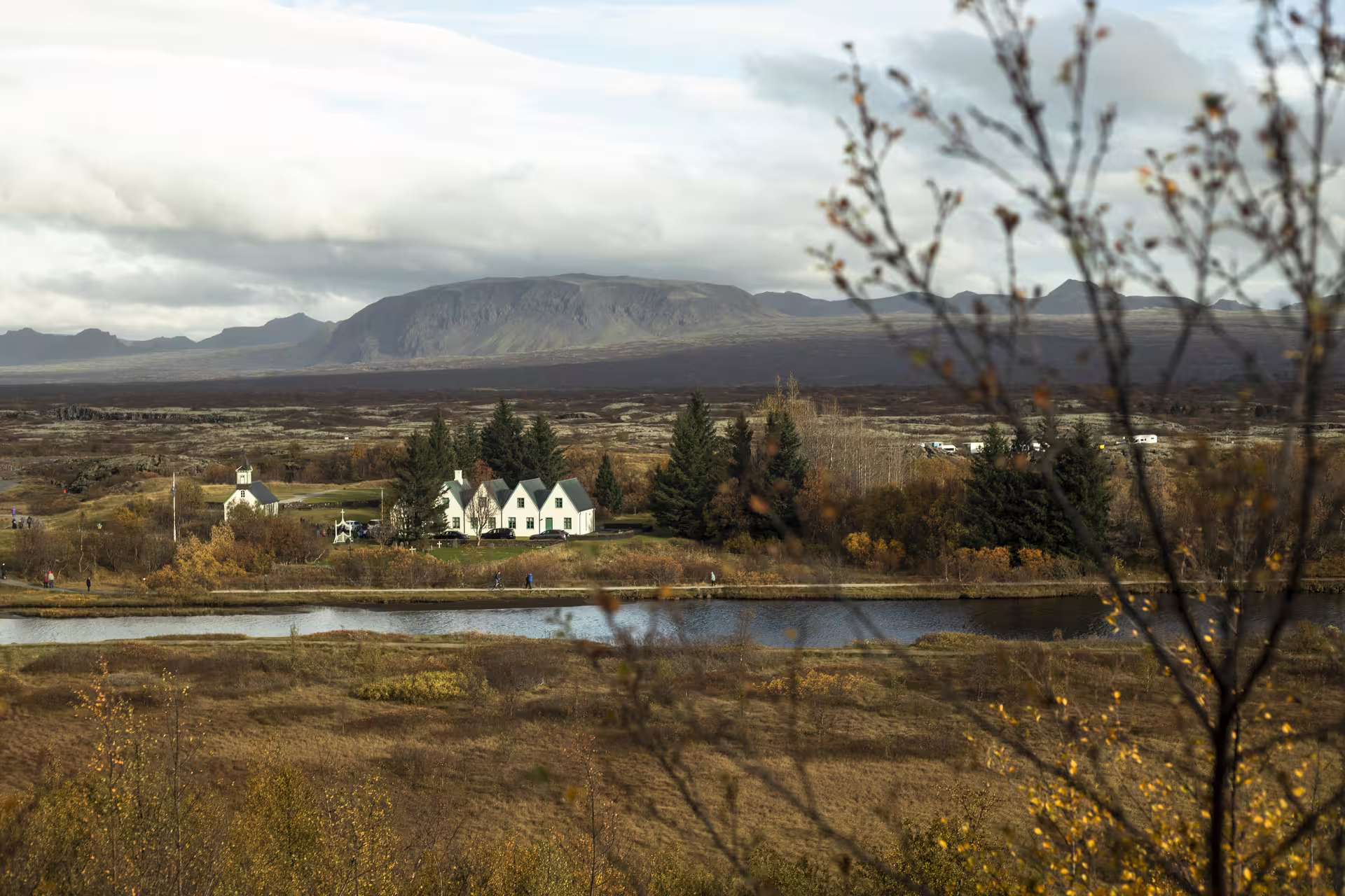 Þingvellir National Park church and farmhouse with river, autumn foliage, and volcanic mountains on Golden Circle tour