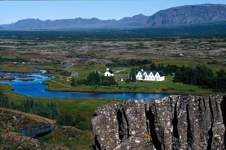 Þingvellir National Park rift valley with white church, winding river, and volcanic mountains, Golden Circle Iceland
