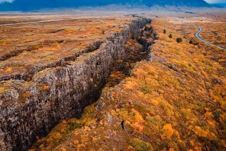 Aerial view of Þingvellir tectonic rift fissure surrounded by autumn foliage, Iceland Golden Circle