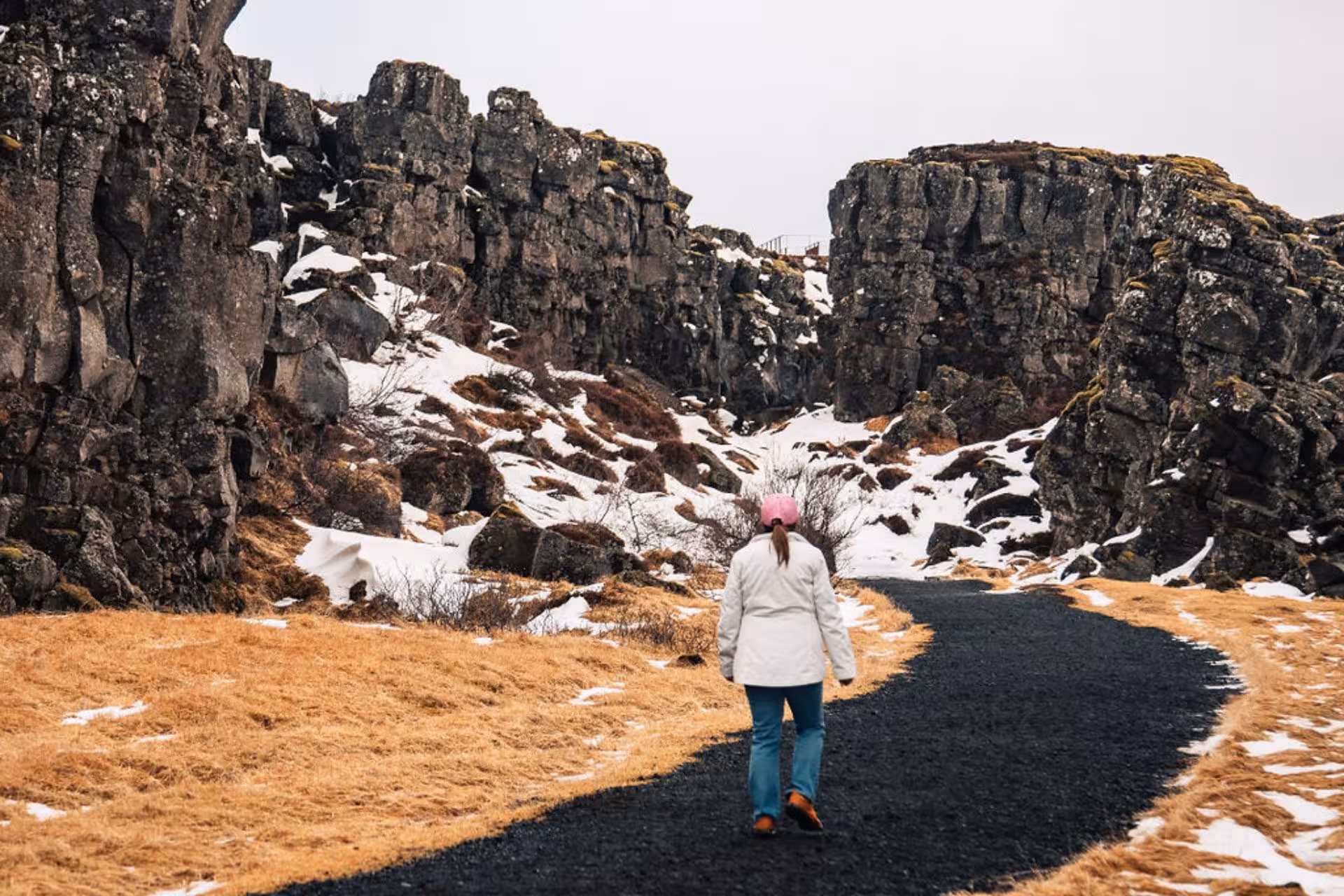 Woman hiking through Þingvellir rift valley canyon on Iceland's Golden Circle in winter