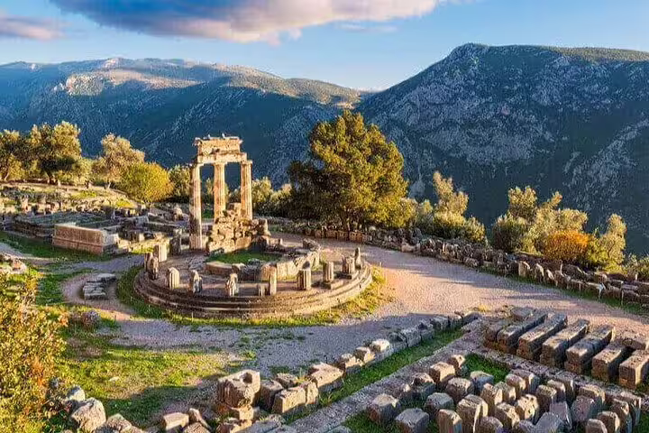 Tholos of Athena Pronaia at Delphi with Parnassus mountains, stop on a private full-day tour from Athens