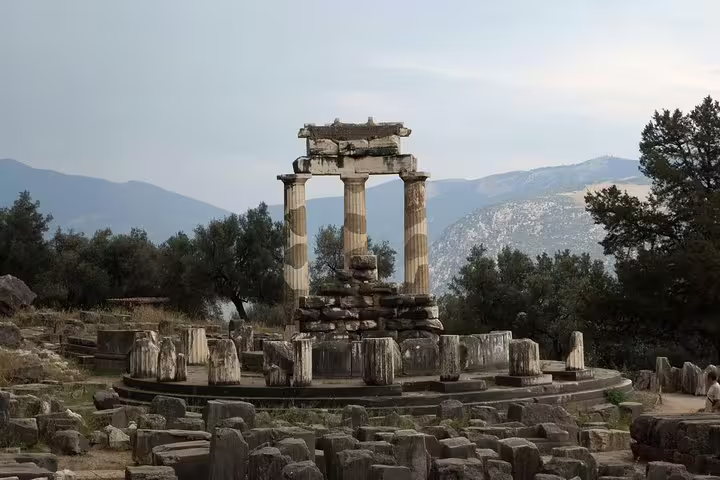 Tholos of Athena Pronaia in Delphi with mountain views, highlight of private Delphi tour from Athens