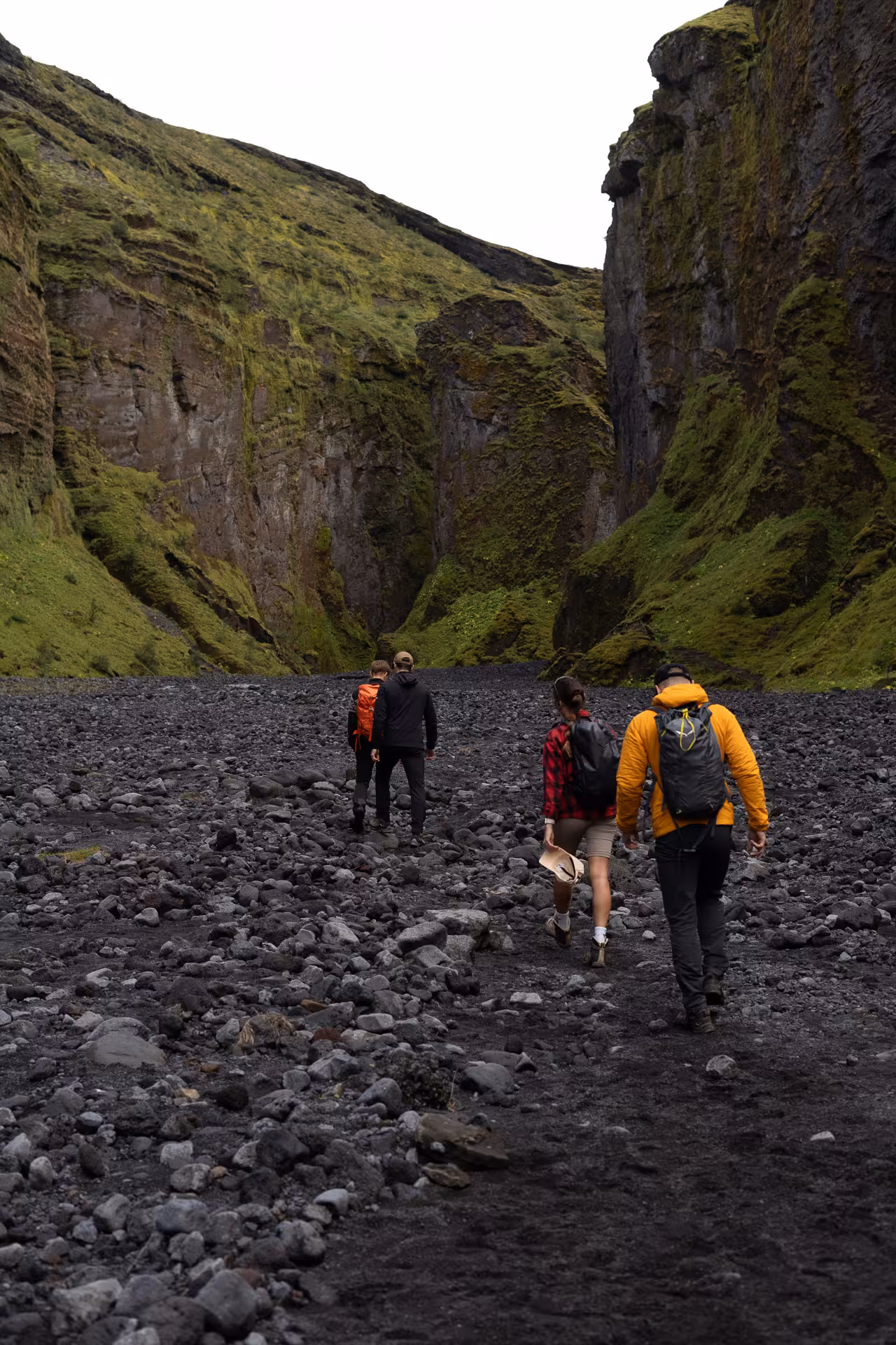 Small group hiking black volcanic riverbed canyon in Þórsmörk on private off-road tour with river crossings