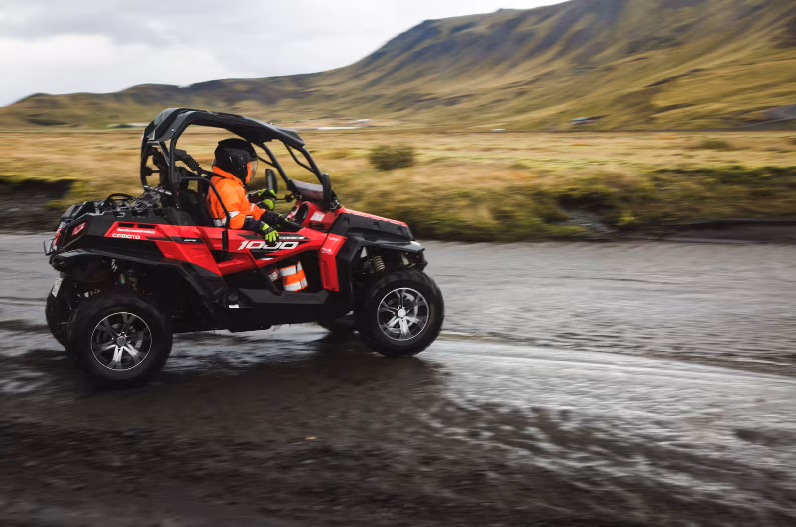 Red CFMOTO 1000 buggy driven through wet highland terrain in Thorsmork, Iceland