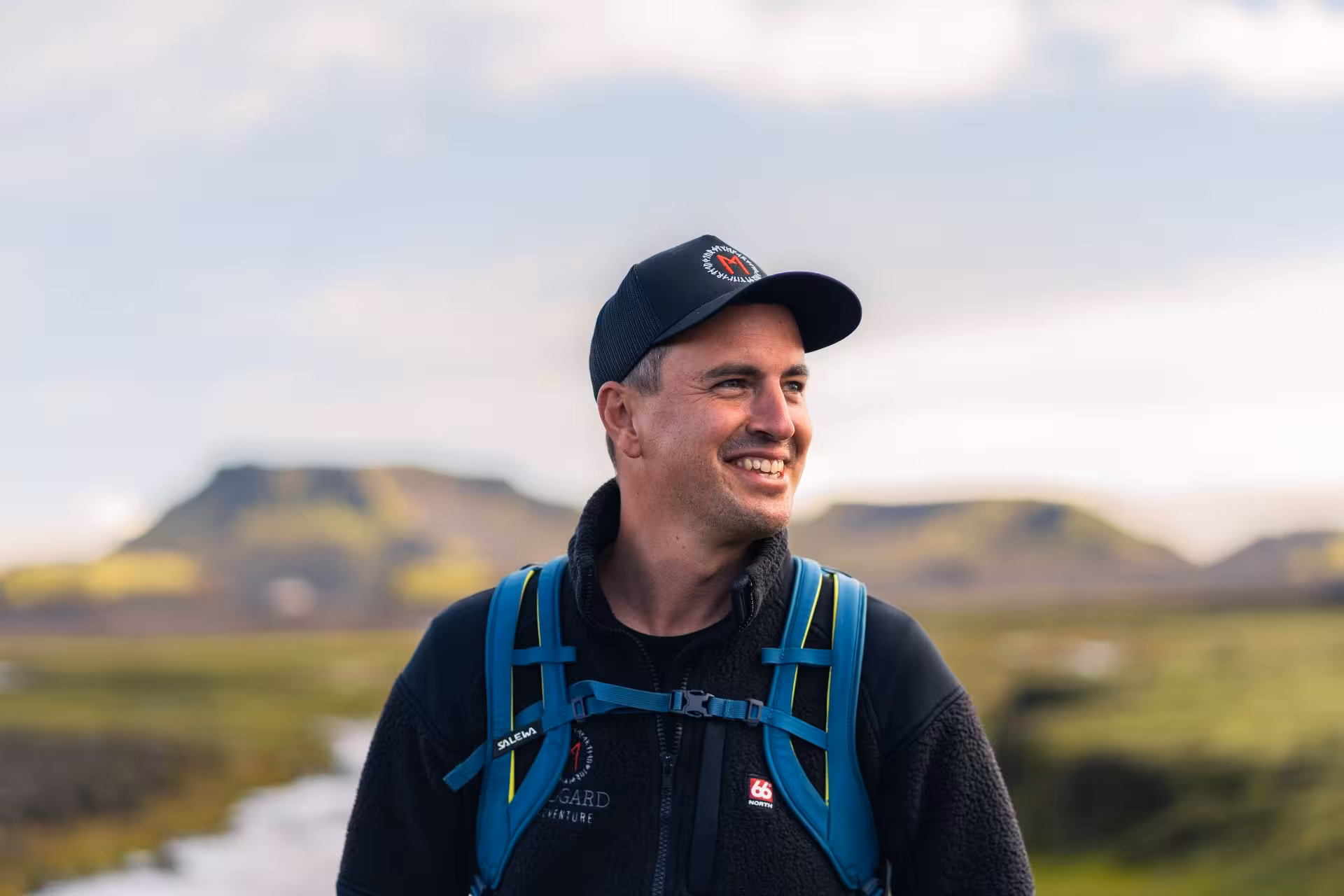 Smiling hiker with backpack in Thorsmork volcanic highland landscape, Iceland