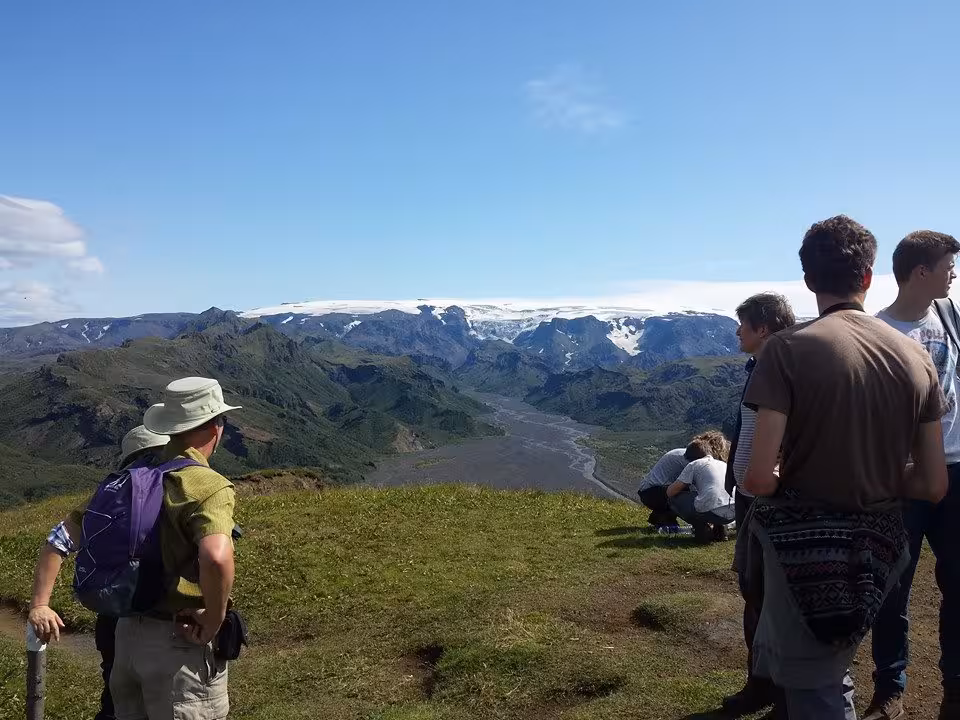 Hikers overlooking Thorsmork valley with glaciers and snow-capped mountains in Iceland
