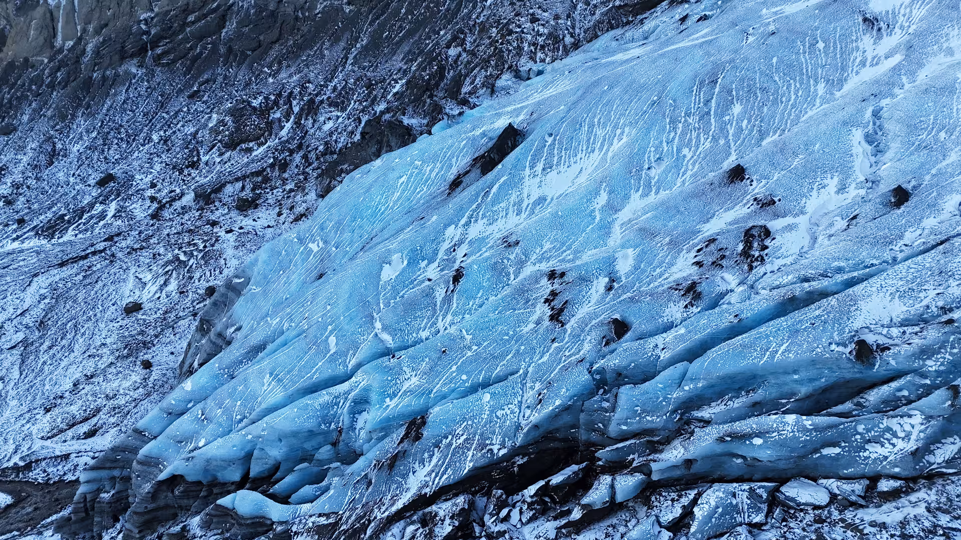 Blue glacier ice with dark rock formations in Iceland Highlands near Thorsmork